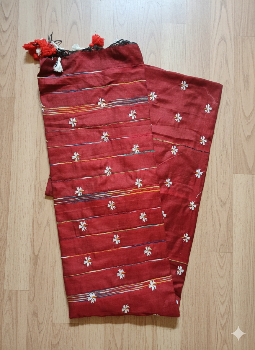 Red fabric with floral patterns on a wooden surface