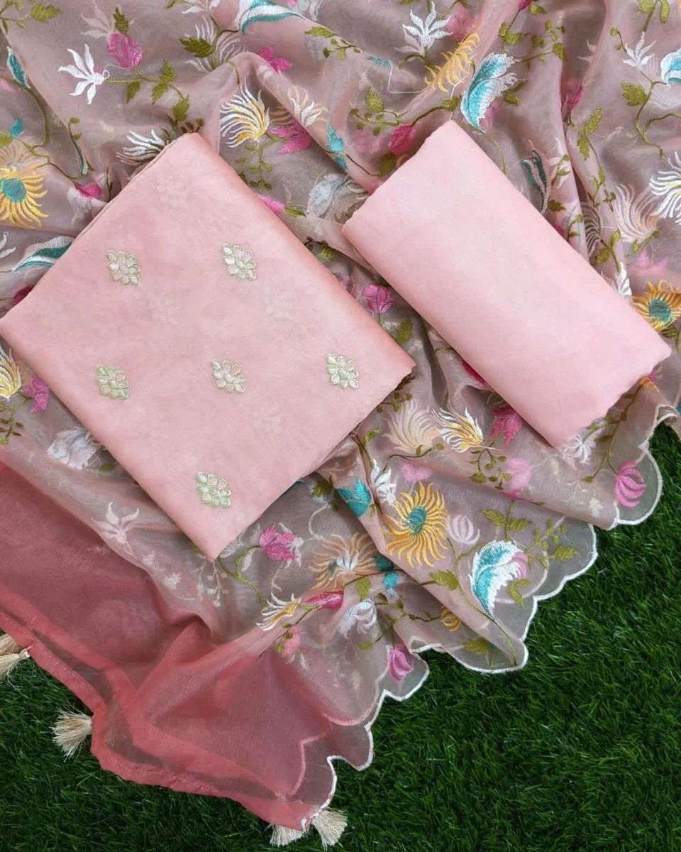 Pink fabric with floral embroidery on a green grass background