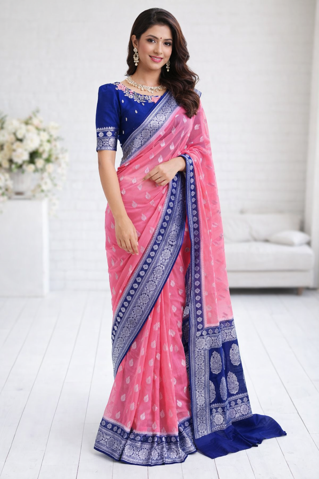 Woman wearing a pink and blue saree in a white room