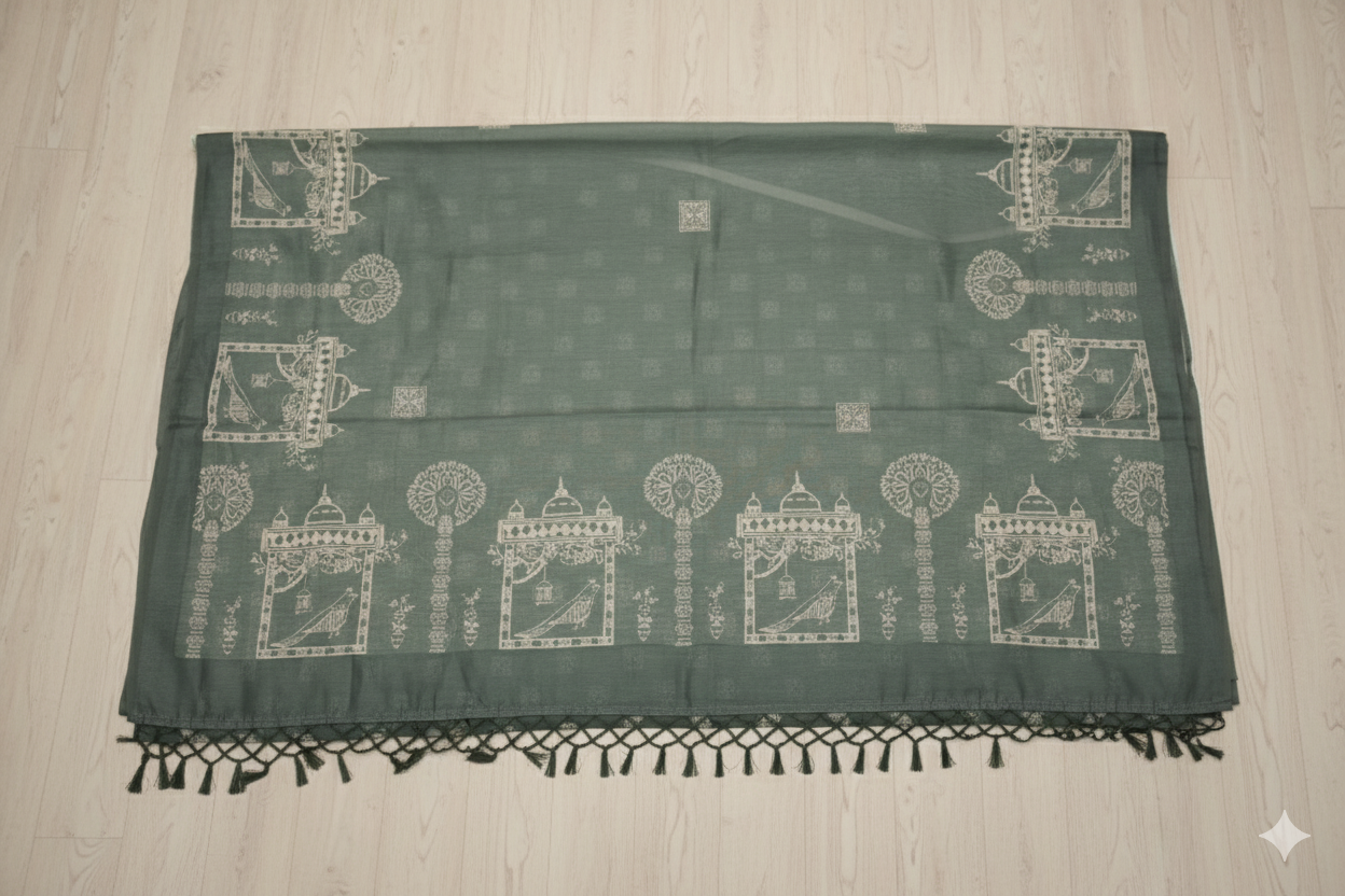 Green saree with white patterns on a wooden floor