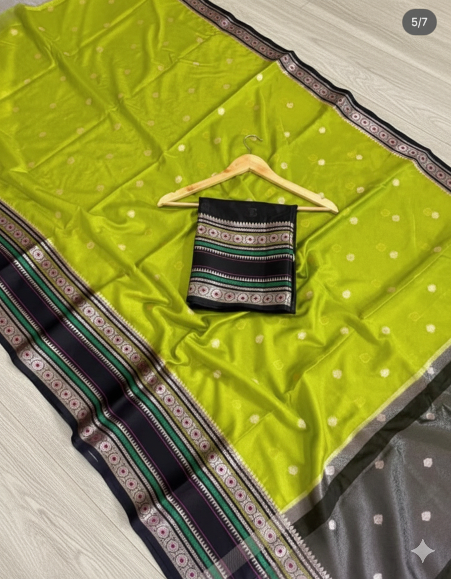 Green saree with white polka dots and a black blouse on a wooden hanger, laid out on a surface.