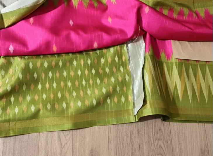 Saree with pink and green patterns on a wooden surface