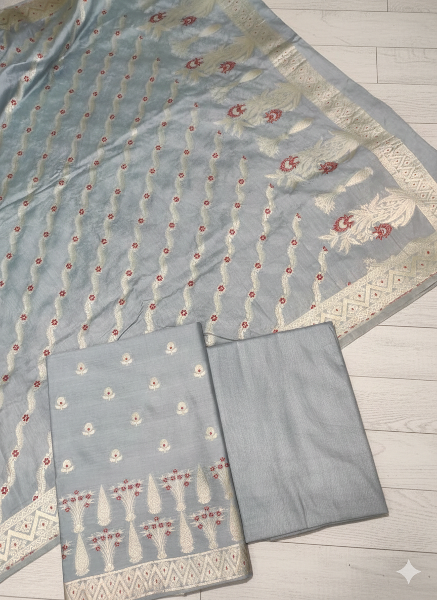 Light blue fabric with intricate patterns on a wooden surface