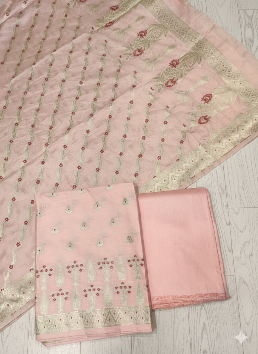 Pink embroidered fabric with a smaller piece on a light wooden surface