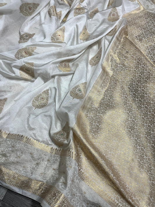 White fabric with gold leaf patterns on a textured surface