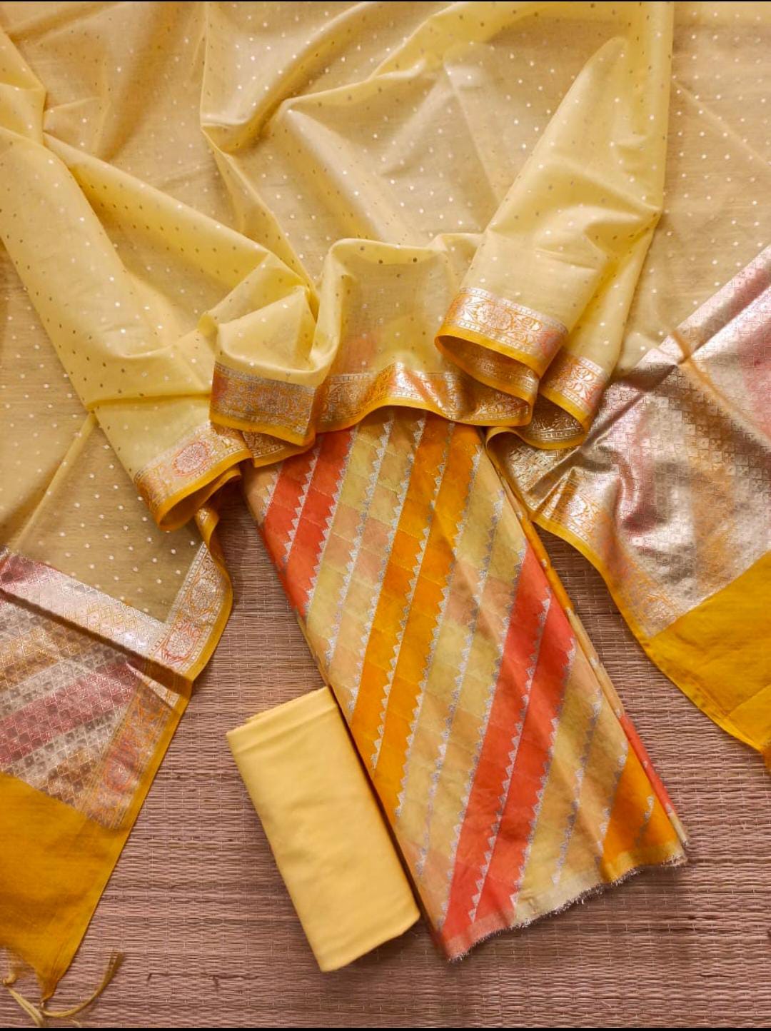 Yellow fabric with patterned edges on a wooden surface