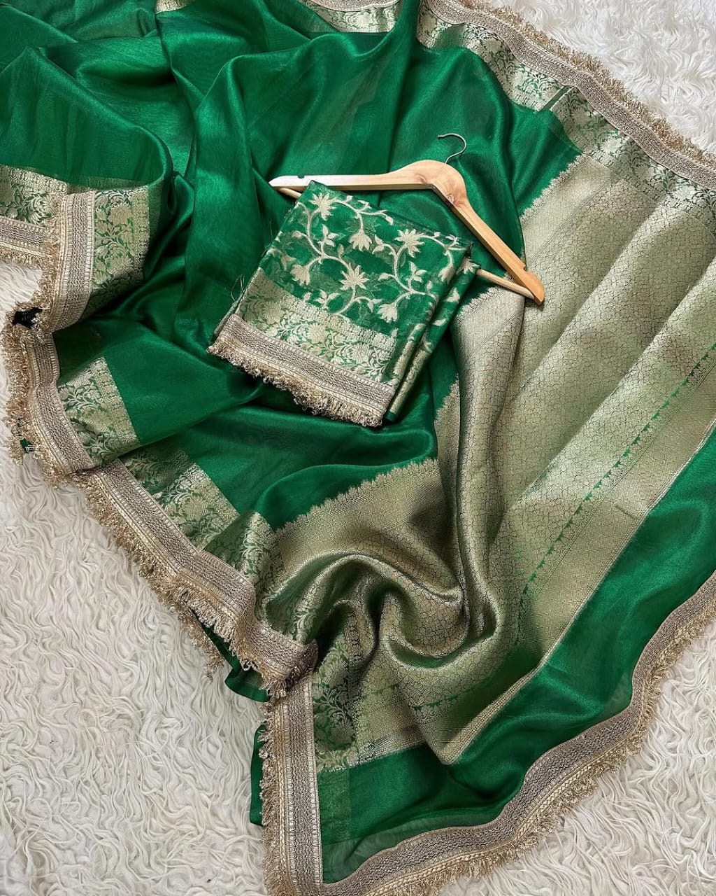 Green saree with a hanger on a textured surface