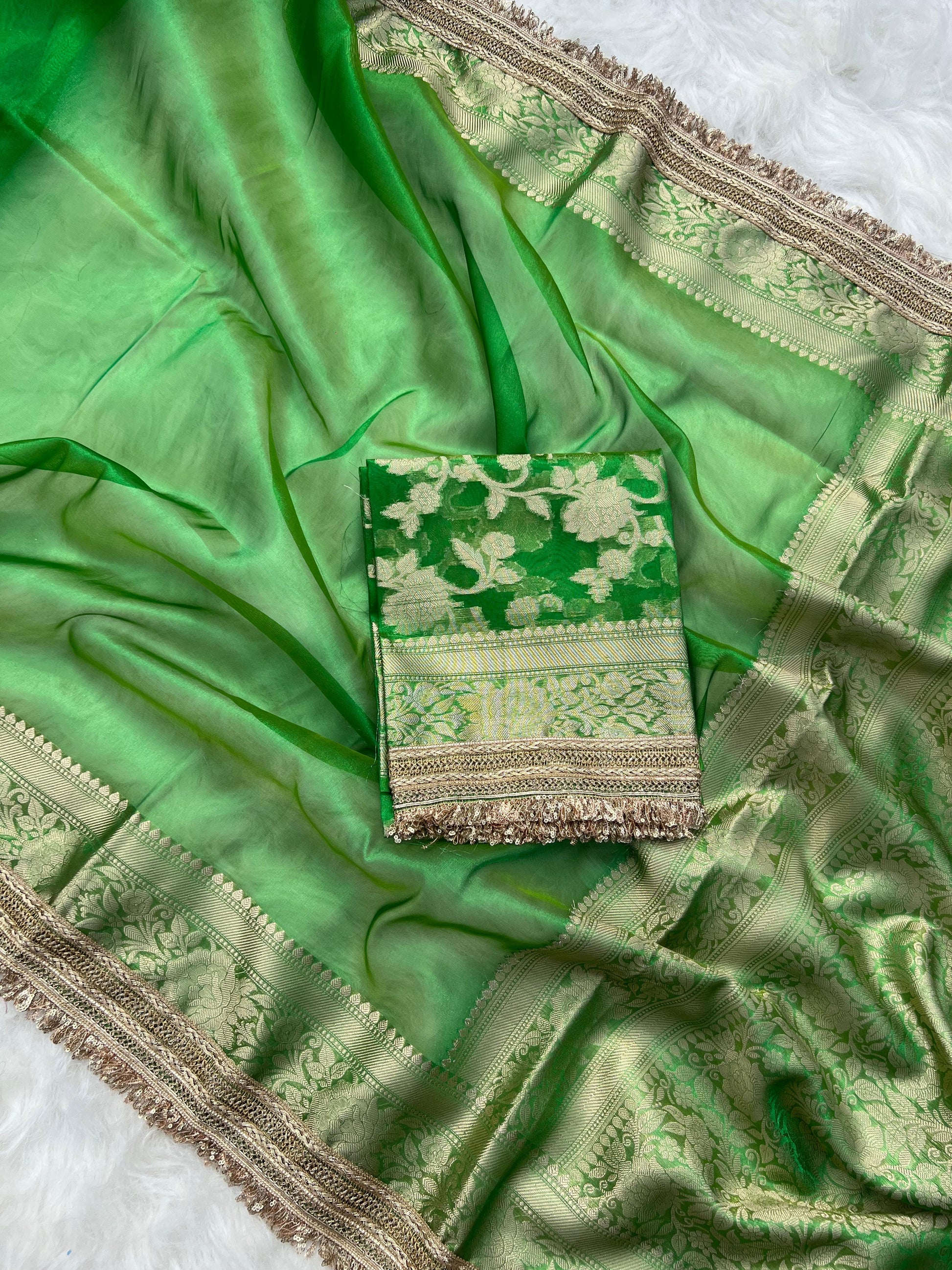 Green saree with intricate patterns on a white background