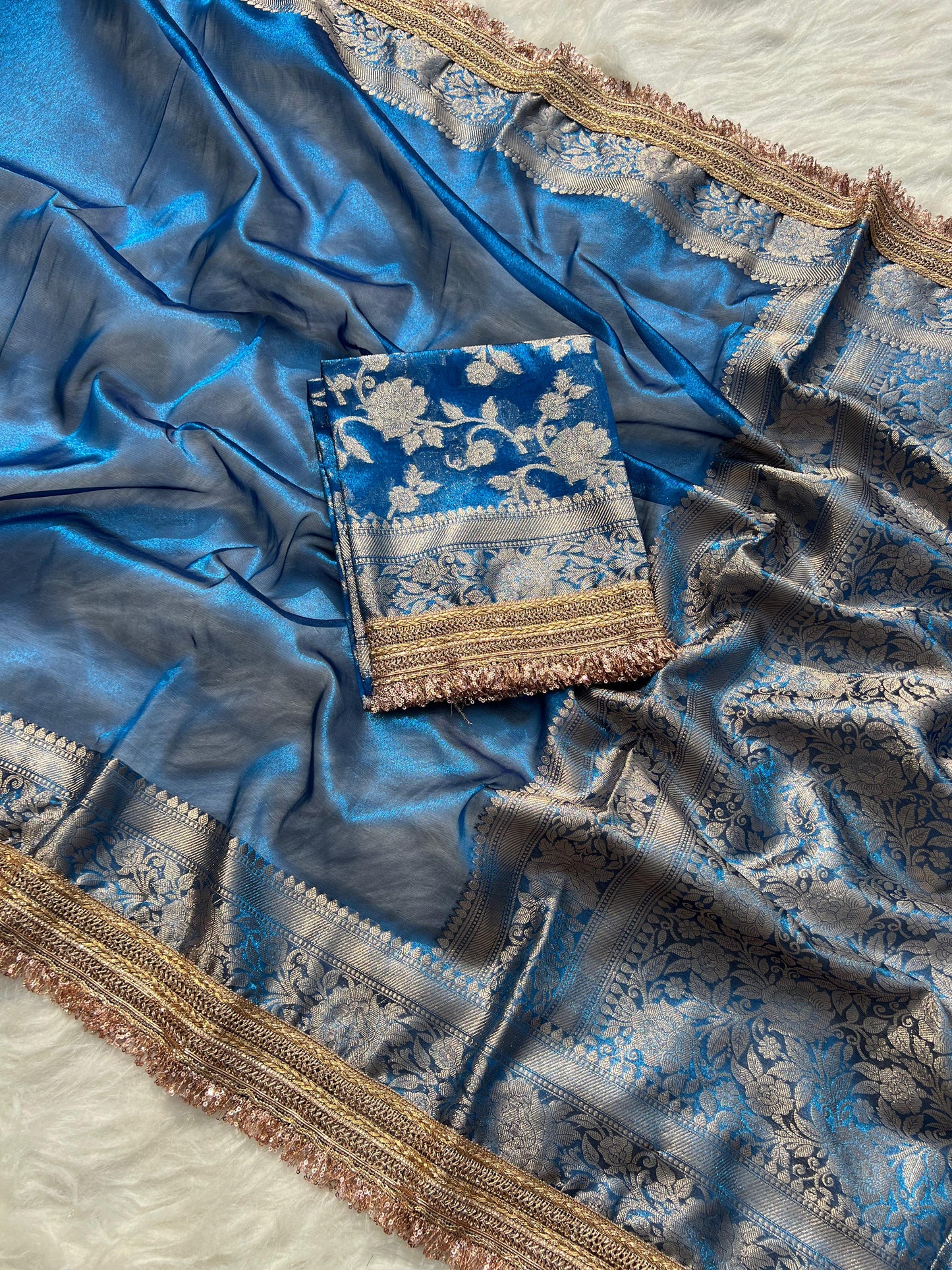 Blue saree with intricate patterns on a textured surface