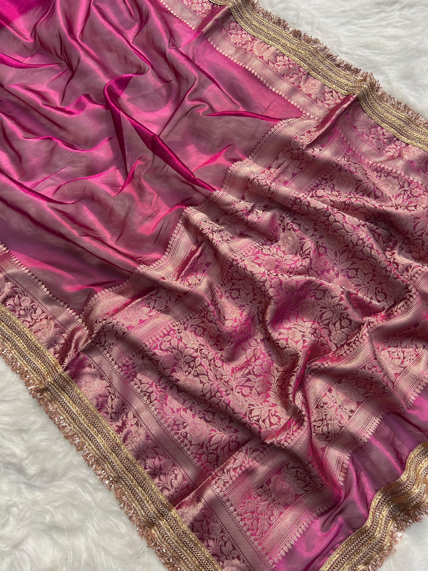 Pink saree with intricate gold patterns on a white background