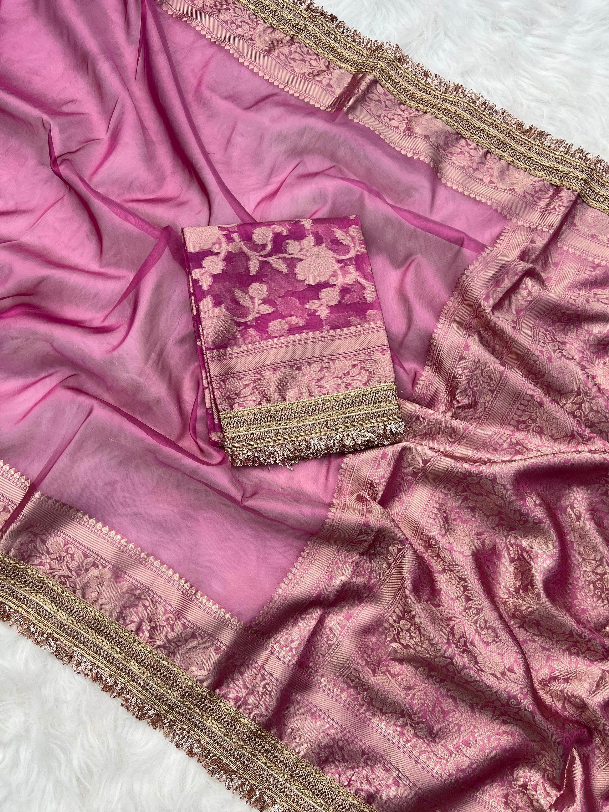 Pink saree with intricate patterns on a white background
