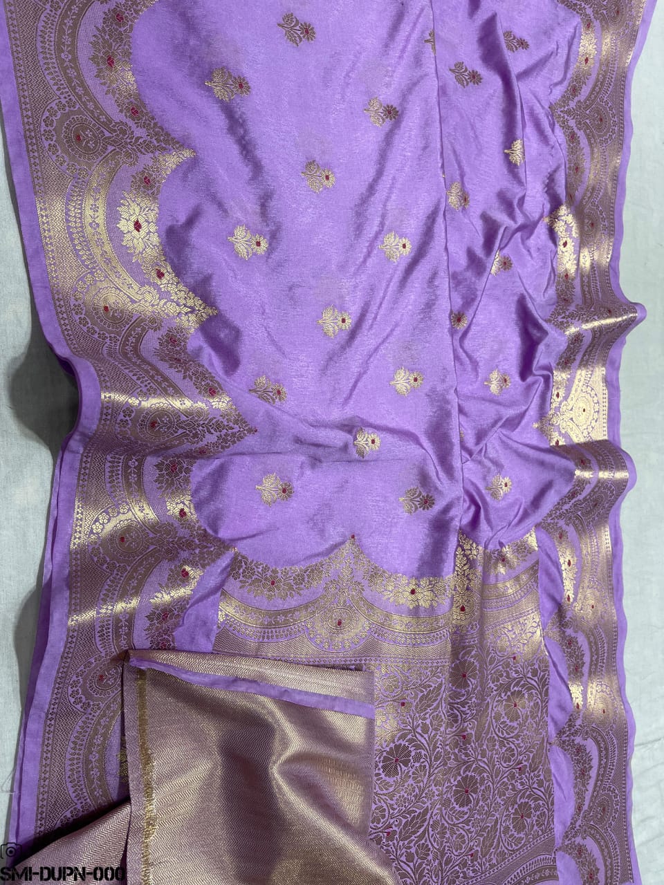 Purple dupatta with gold embroidery on a light blue background