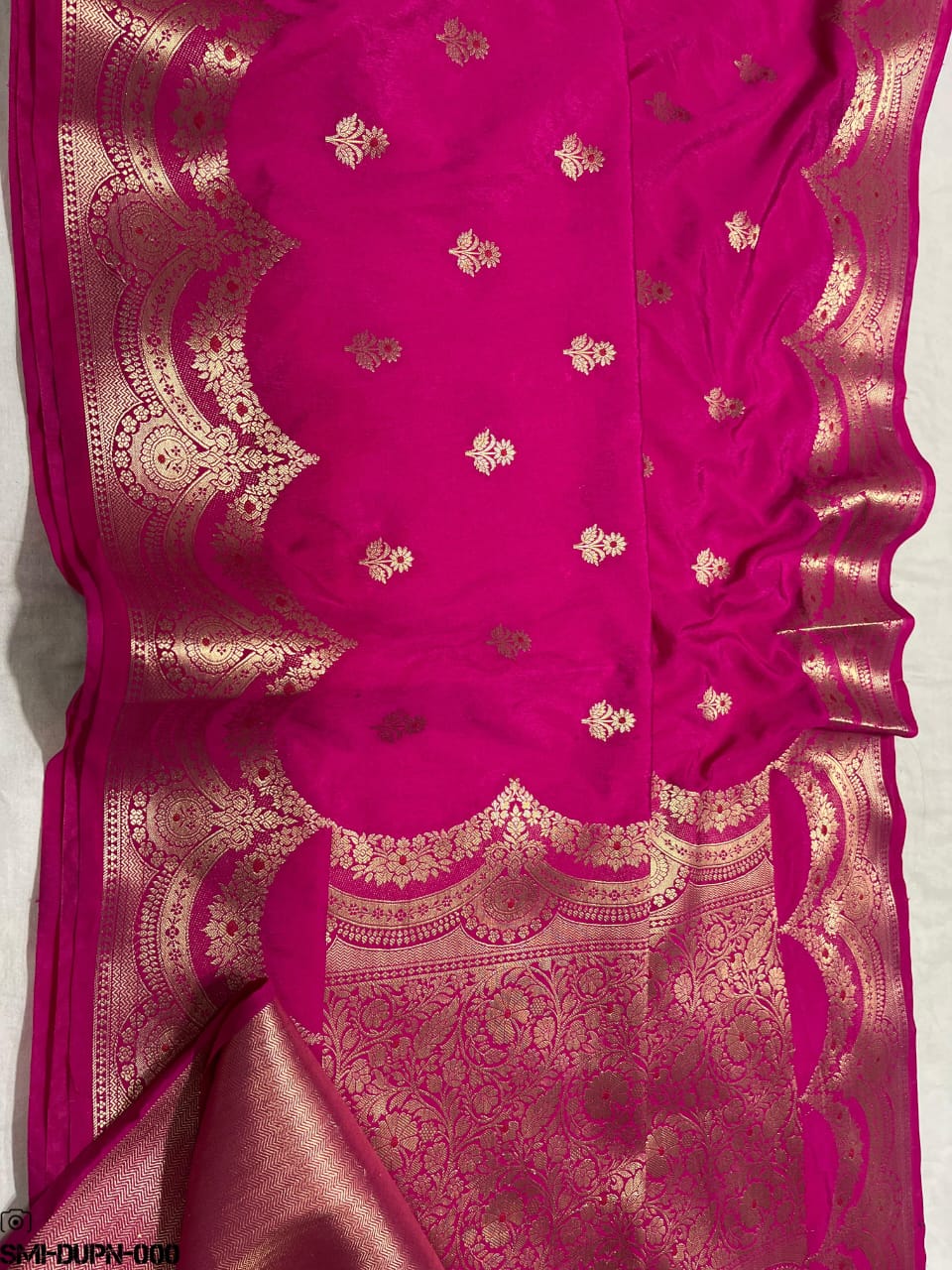 Pink dupatta with intricate gold patterns on a white background
