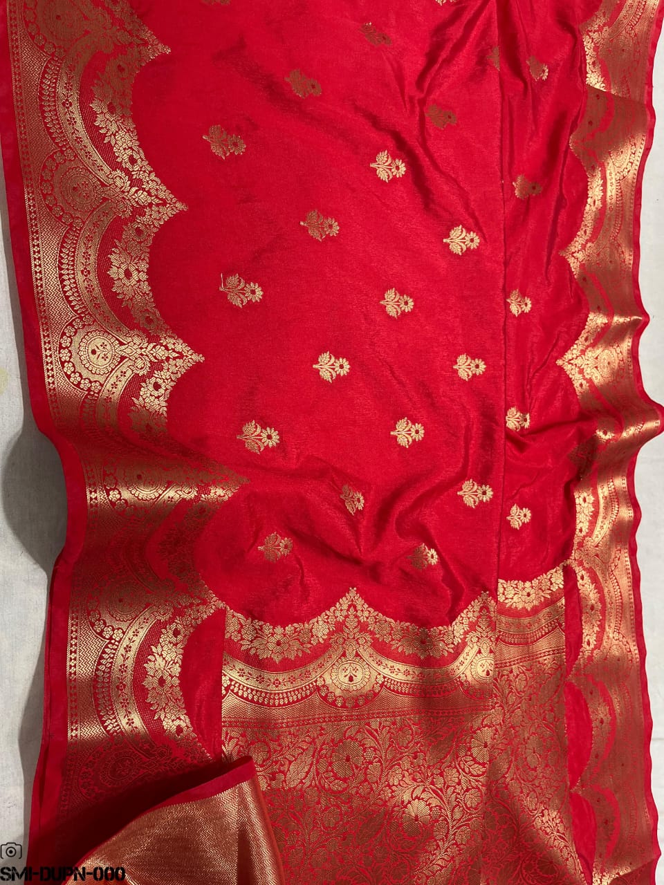 Red fabric with gold embroidery on a white background