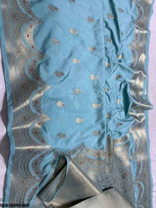 Light blue fabric with intricate silver embroidery on a white background