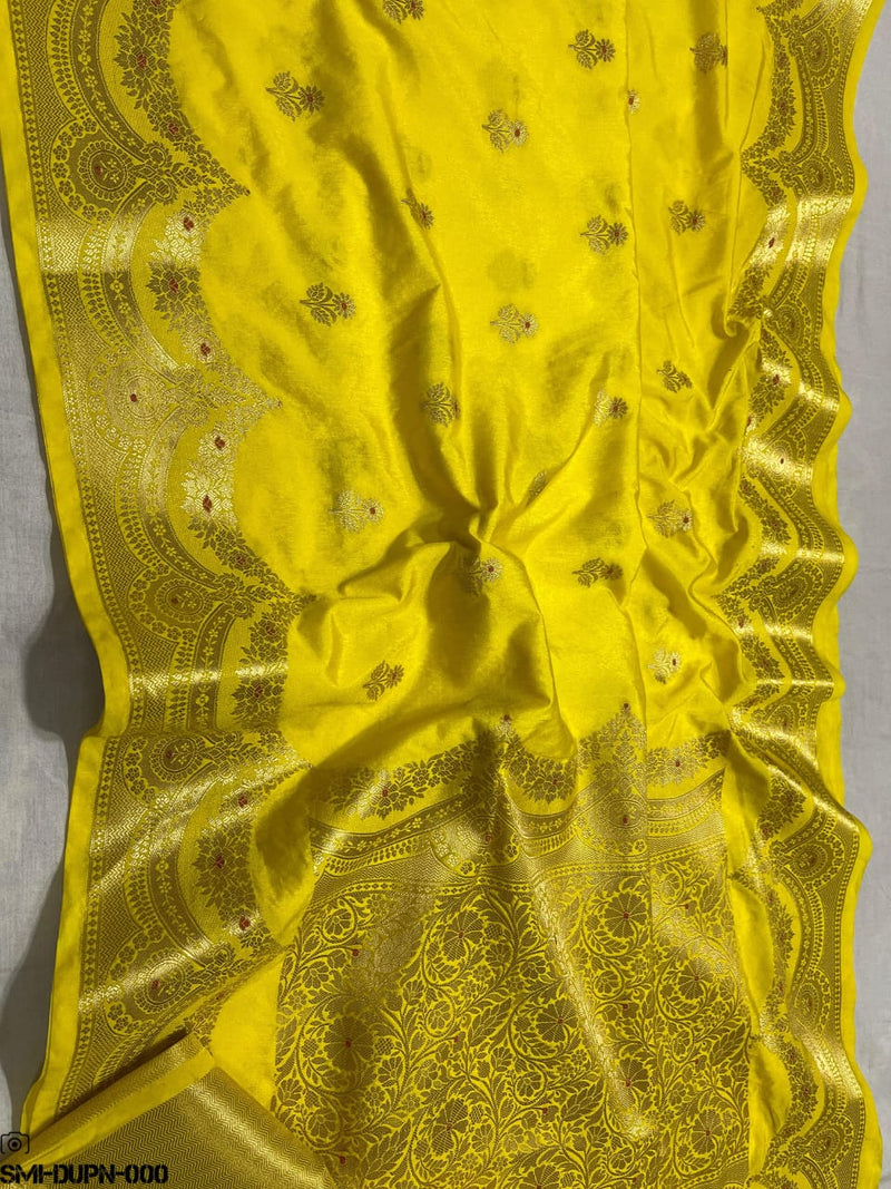 Yellow fabric with intricate gold patterns on a gray background