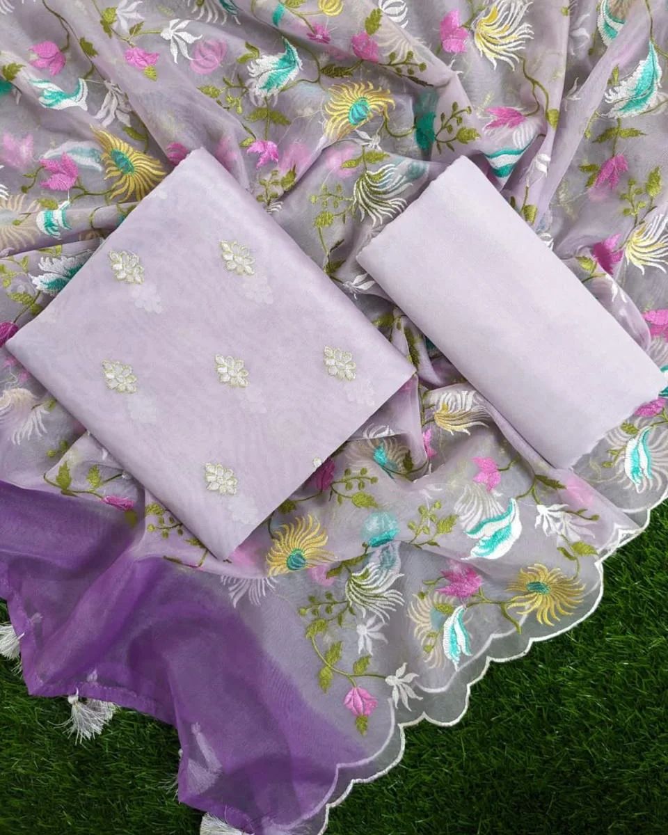Embroidered fabric with floral patterns on a green grass background