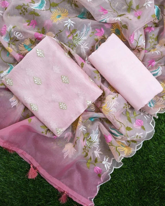 Pink fabric with floral embroidery on a green grass background