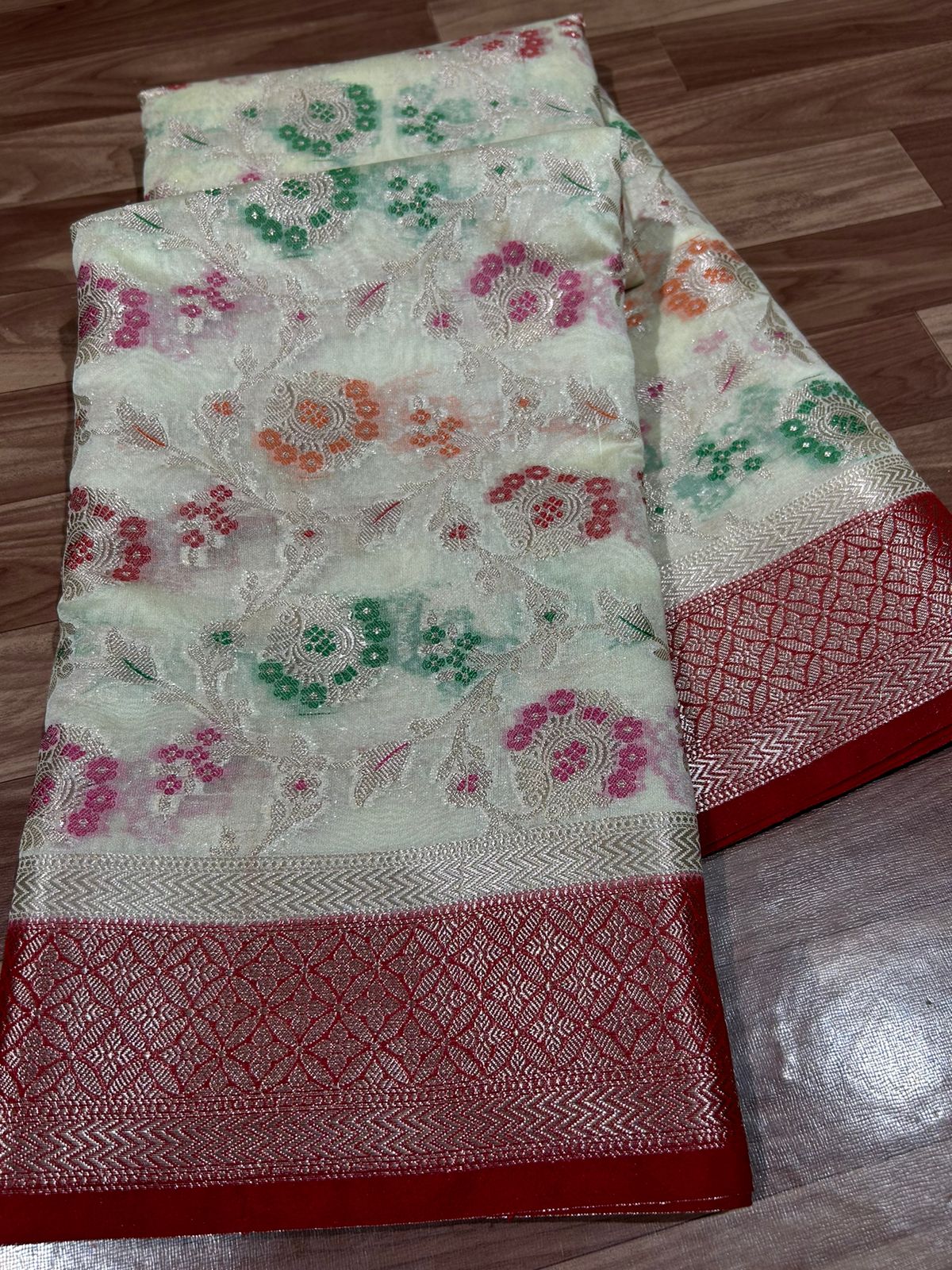 Embroidered fabric with floral patterns on a wooden floor