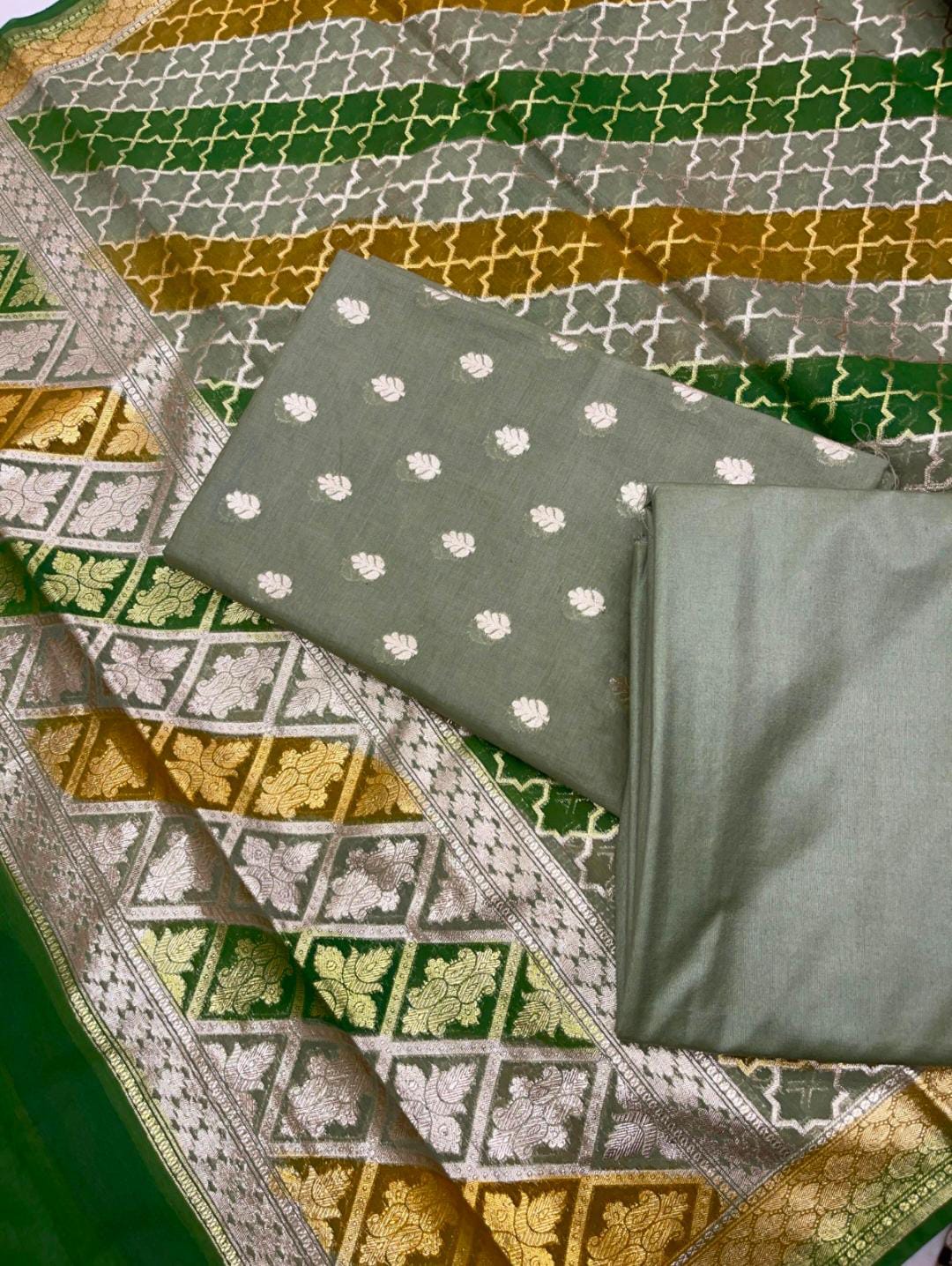 Green fabric with white floral patterns on a patterned background