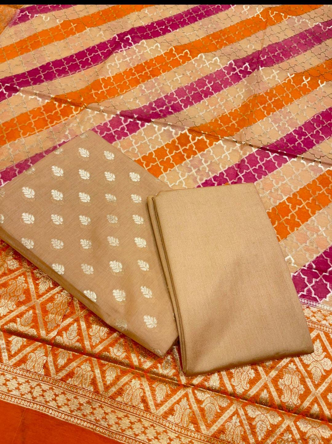 Folded fabric with beige pattern on a colorful striped background