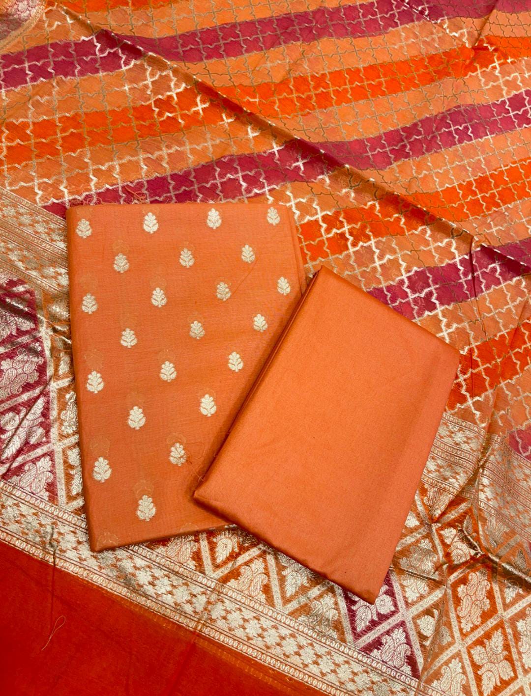 Orange fabric with white patterns on a patterned background