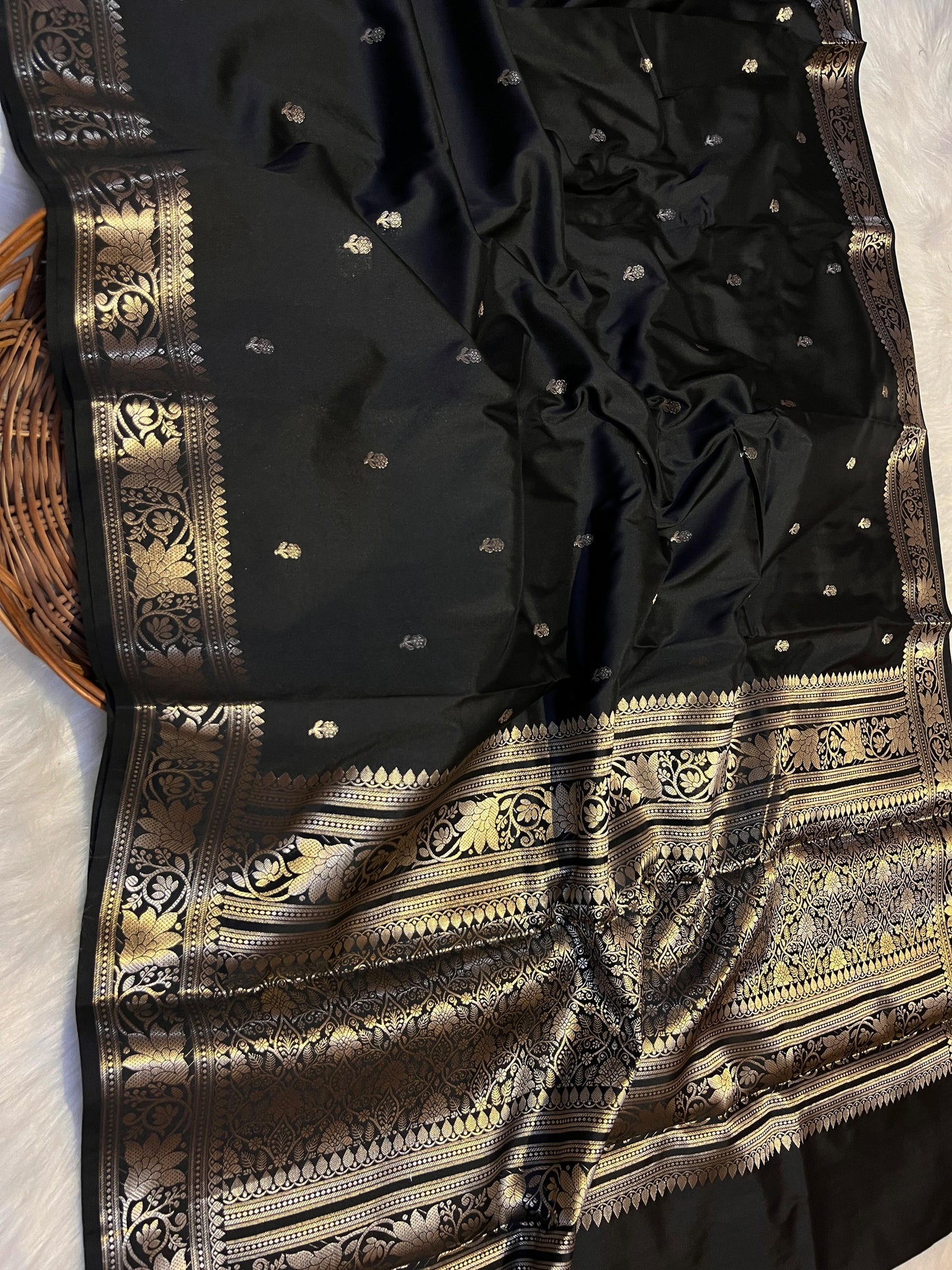 Black saree with gold embroidery on a white background
