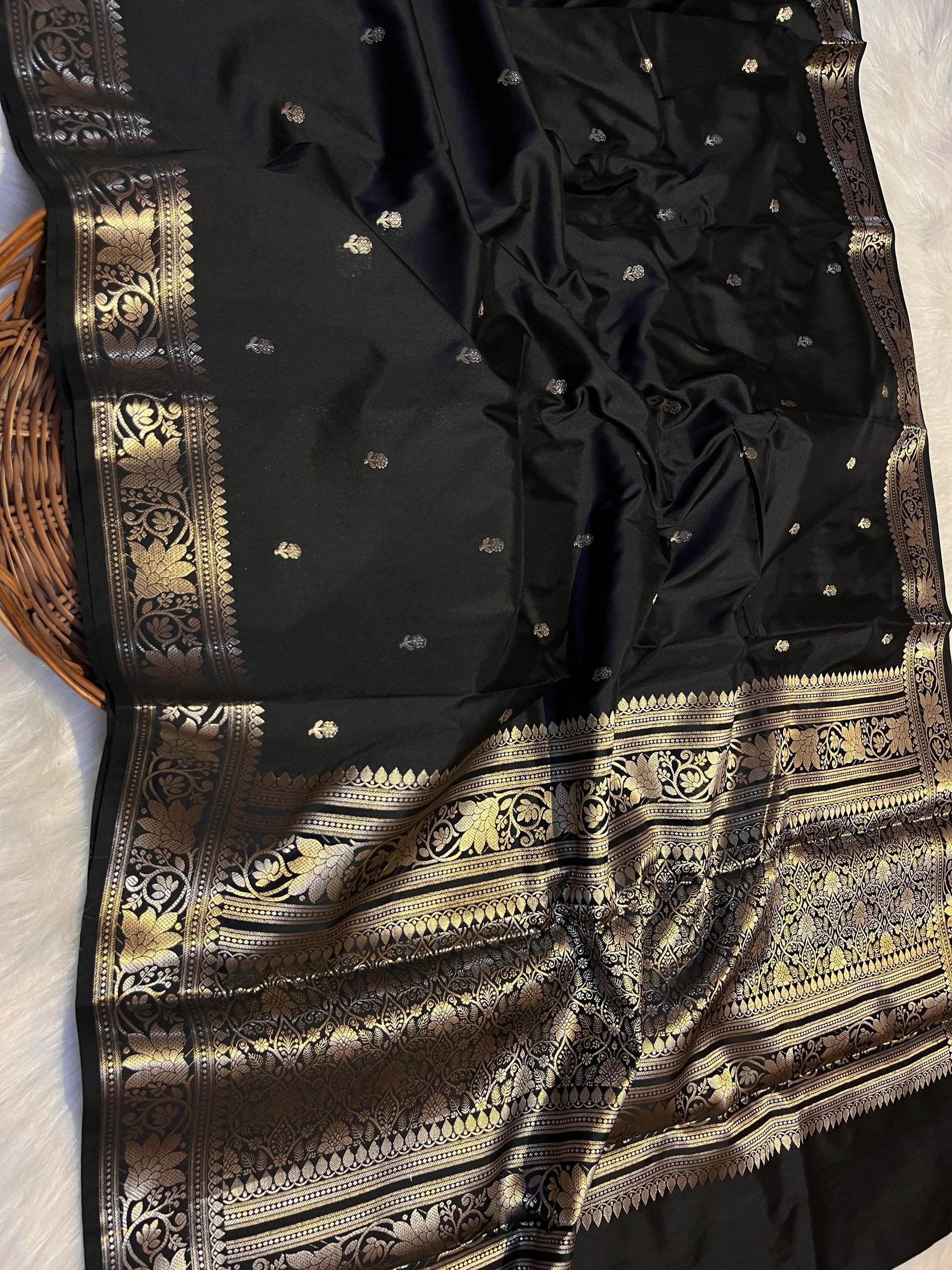 Black saree with gold embroidery on a white background