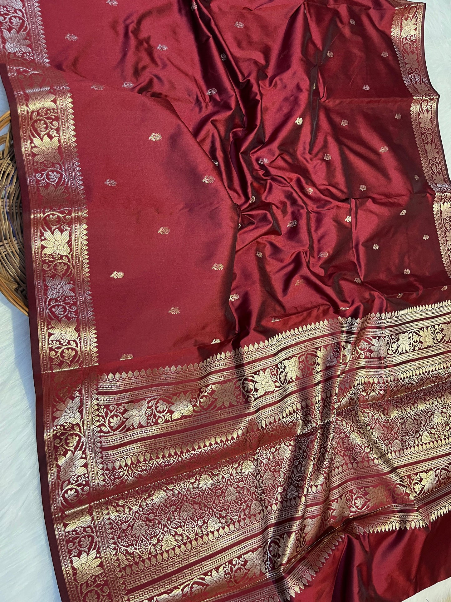 Red saree with gold patterns on a white background