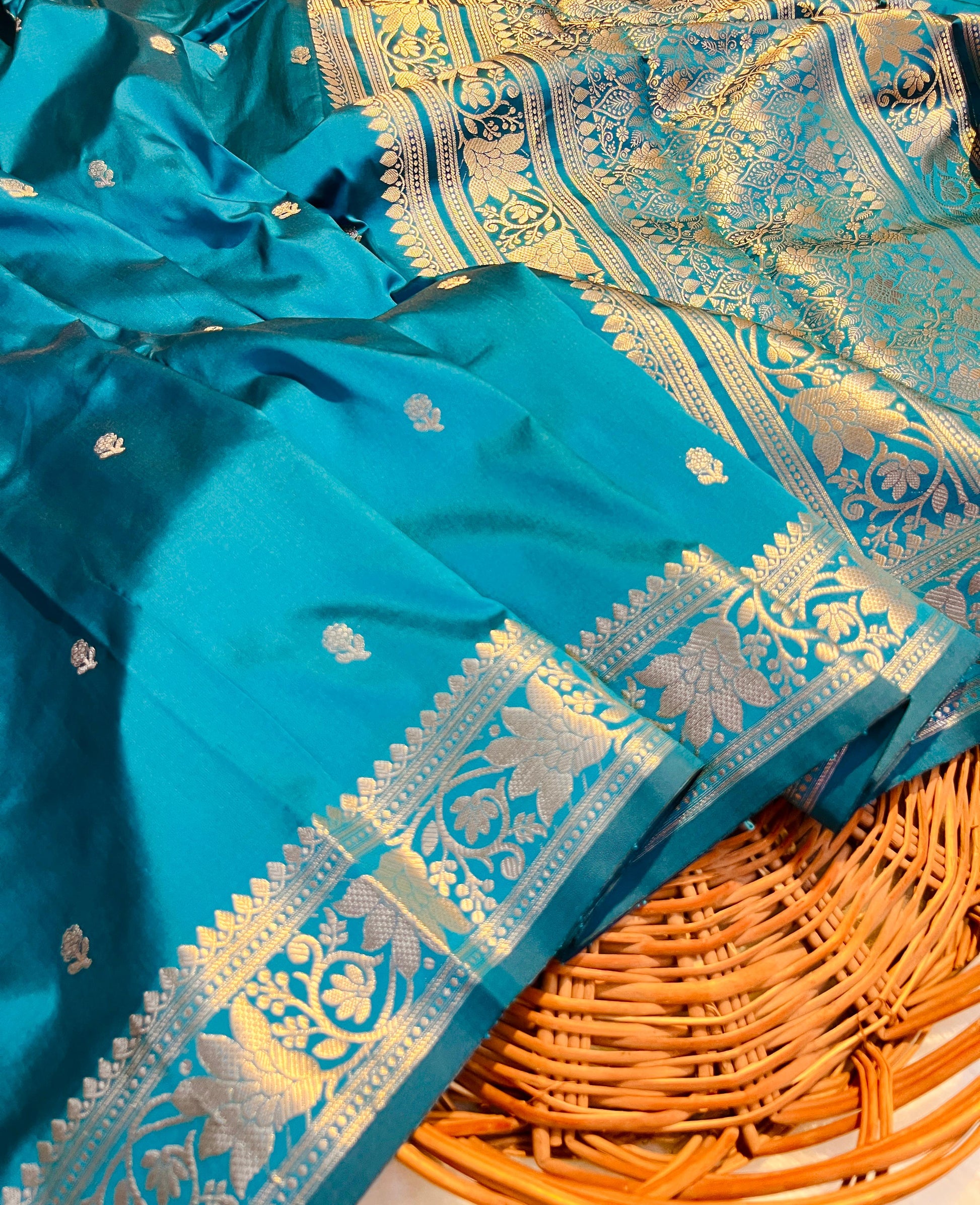 Blue saree with gold patterns on a woven basket