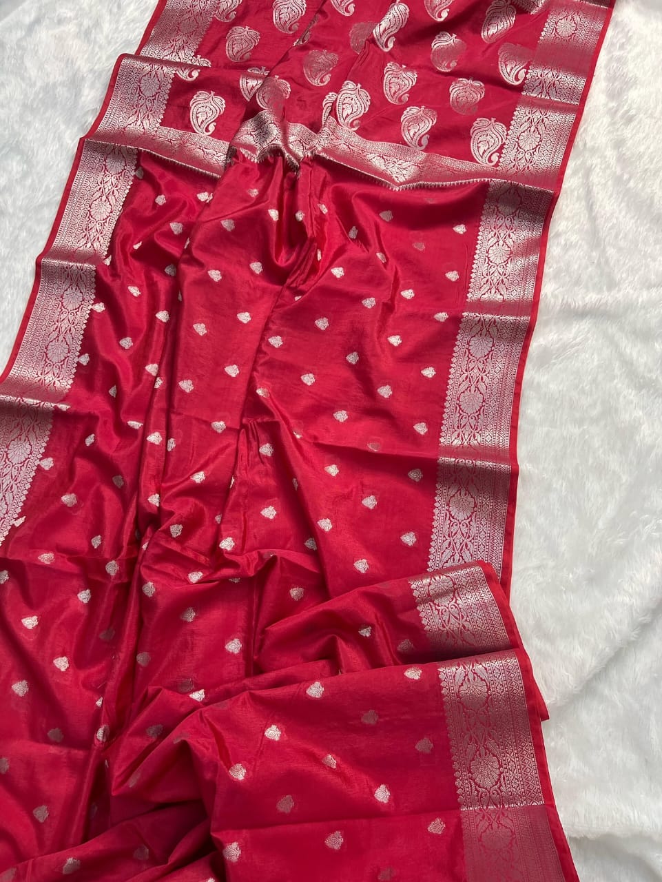 Red saree with white patterns on a white background