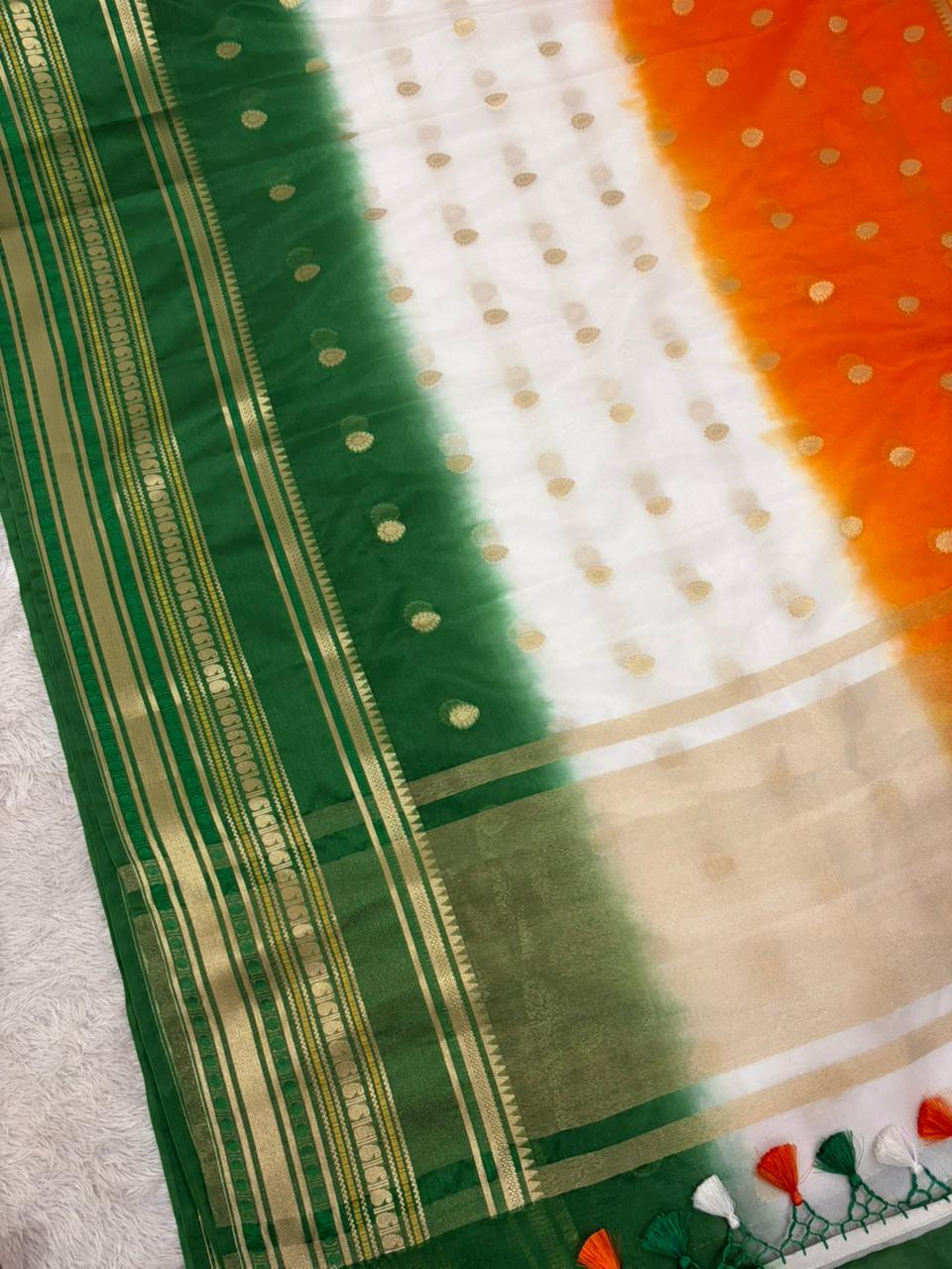 Sari with green, white, and orange patterns on a neutral background