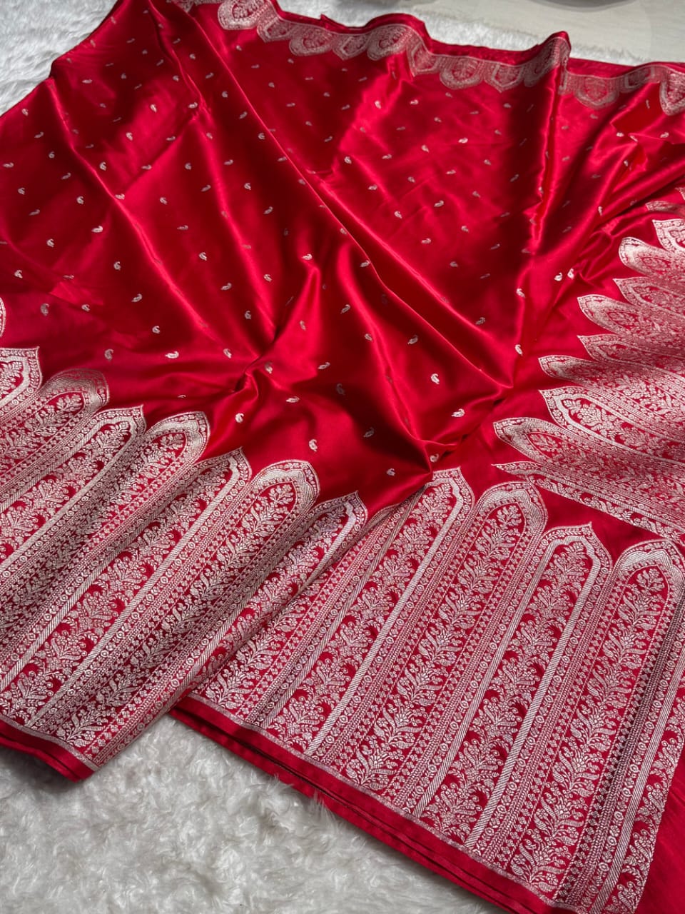 Red fabric with white intricate patterns on a light gray background