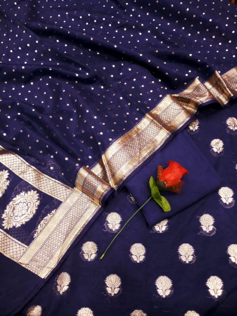 Navy blue saree with white patterns and a red flower on a matching fabric background