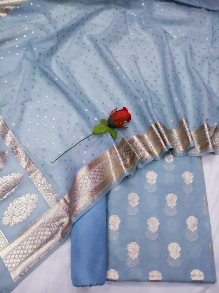Blue fabric with silver embroidery and a red rose on a white background