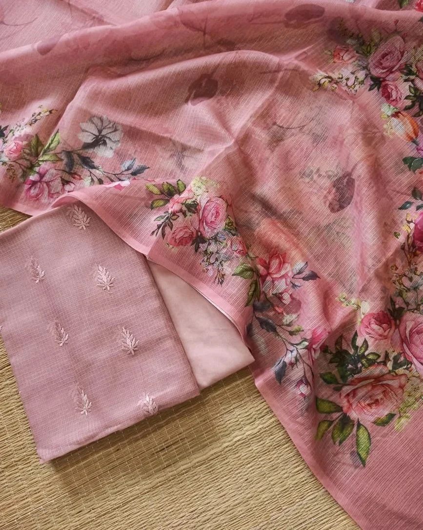 Pink floral fabric and embroidered fabric on a wooden surface