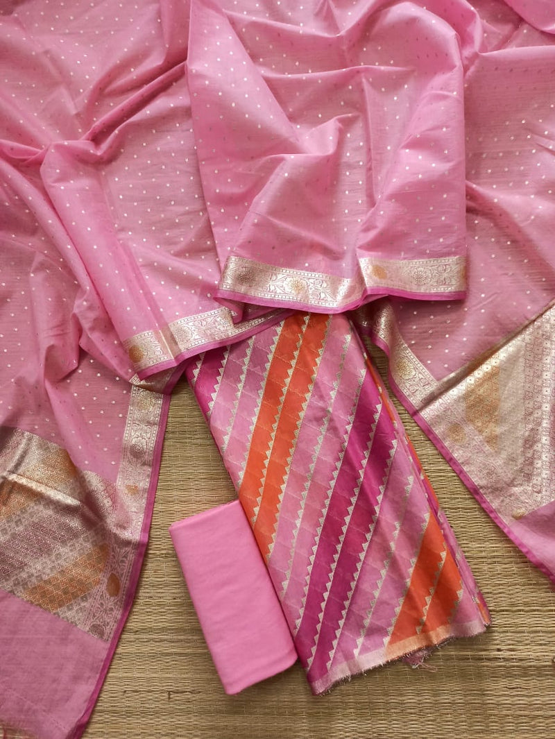 Pink saree with gold border and pink fabric swatch on a wooden surface