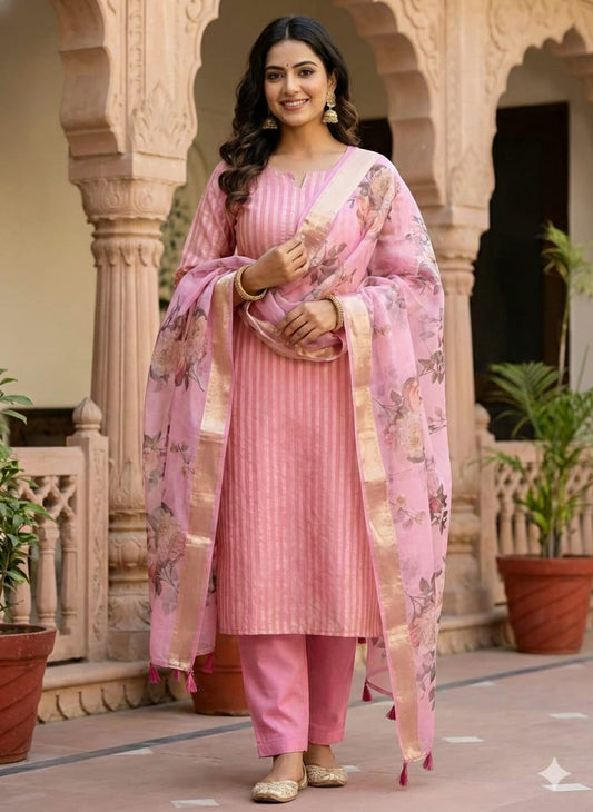 Woman in a pink traditional outfit standing in an architectural setting.