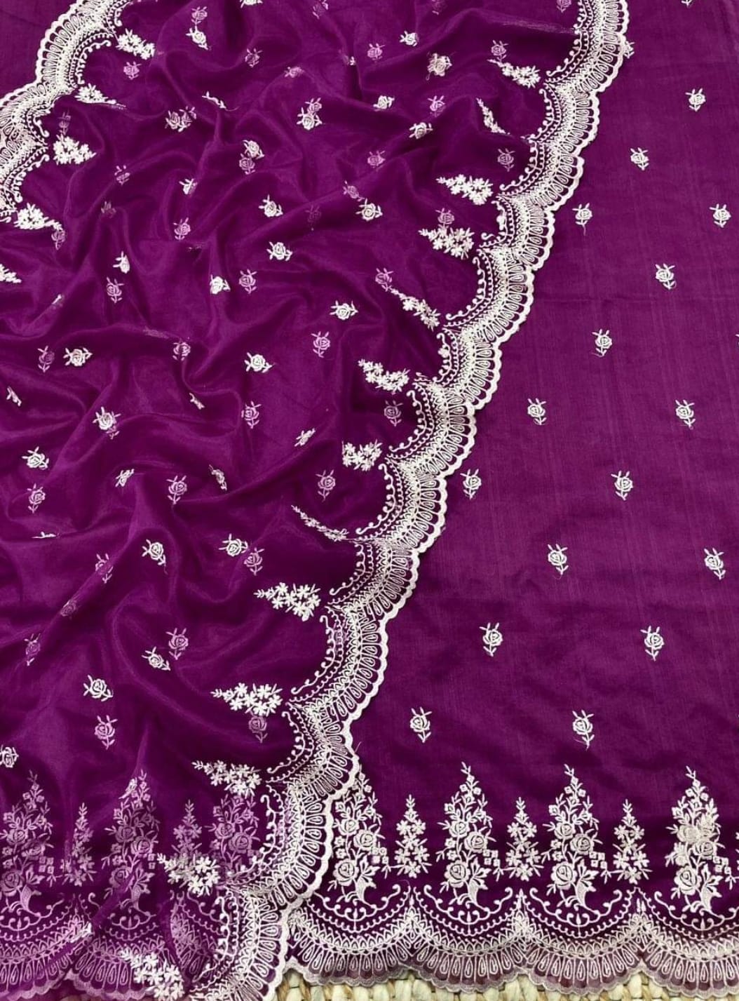 Purple fabric with intricate white embroidery