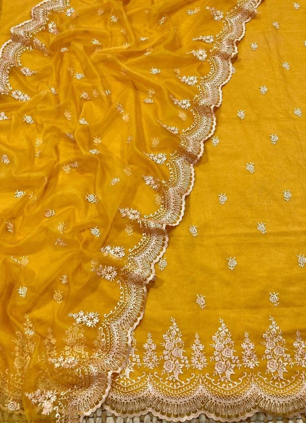 Mustard yellow fabric with intricate white embroidery