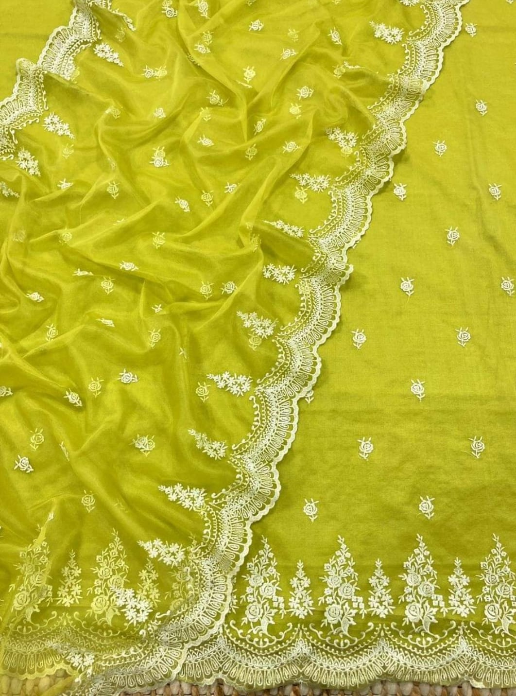 Green fabric with white floral embroidery