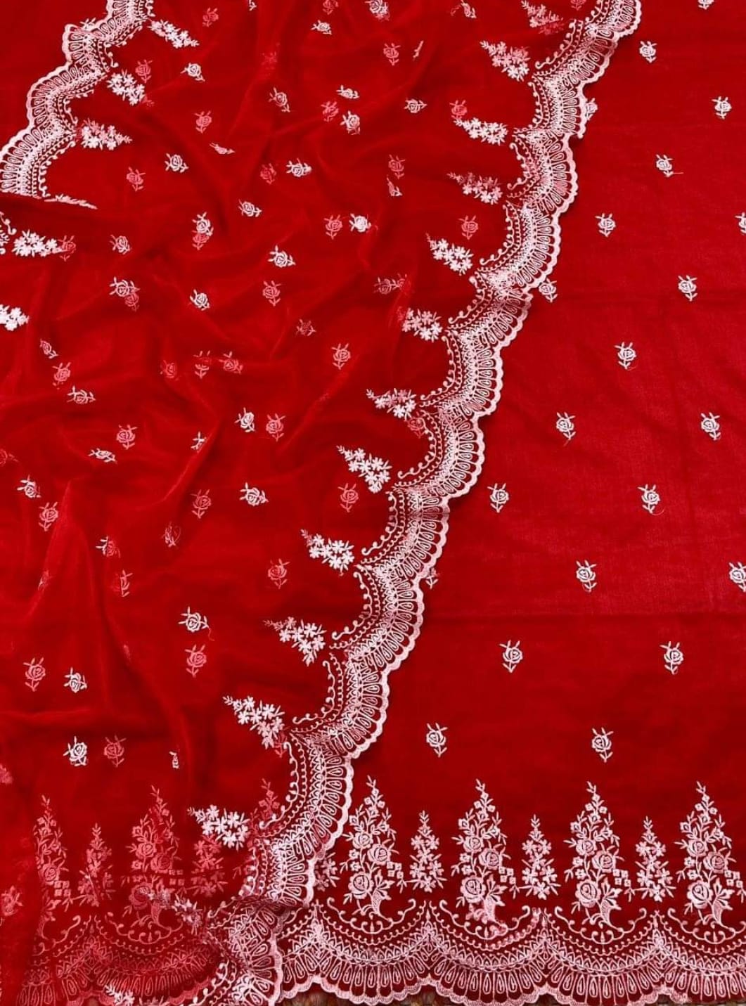 Red fabric with white intricate embroidery