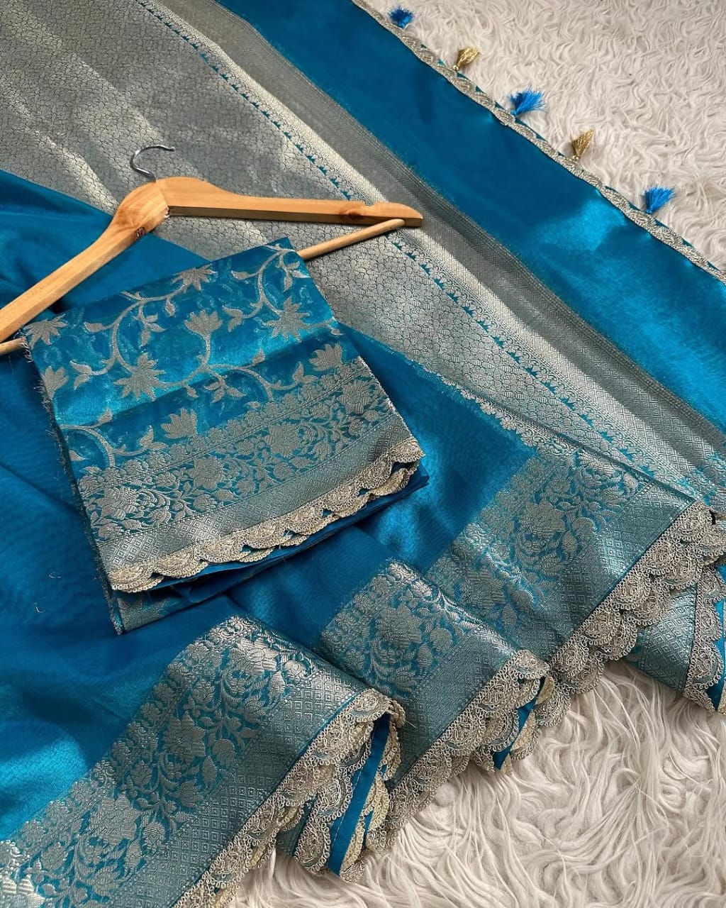 Blue saree with silver patterns on a textured white surface