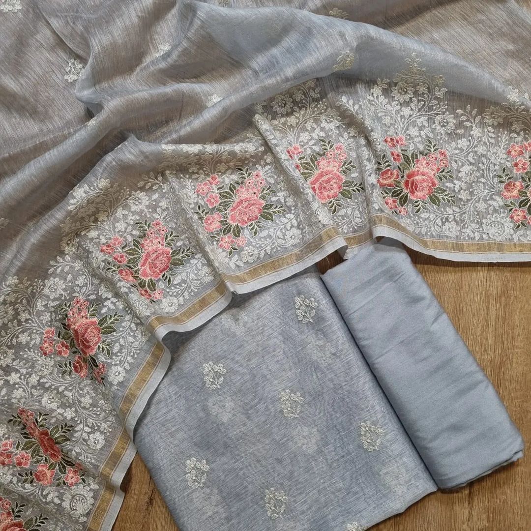 Gray fabric with floral embroidery on a wooden surface