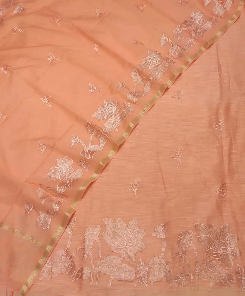Peach-colored fabric with white floral embroidery