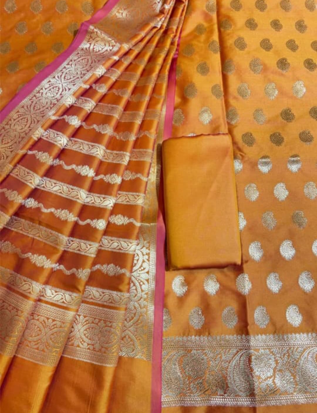 Orange saree with gold patterns and a matching blouse piece.