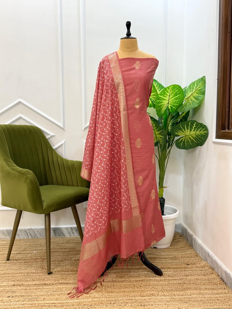 Mannequin wearing a pink saree with a plant and chair in the background