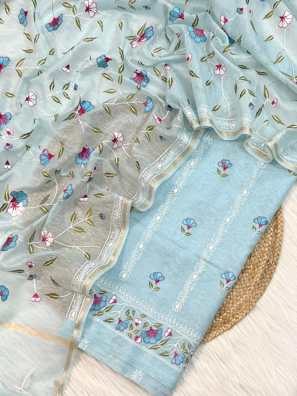Light blue fabric with floral embroidery on a textured surface