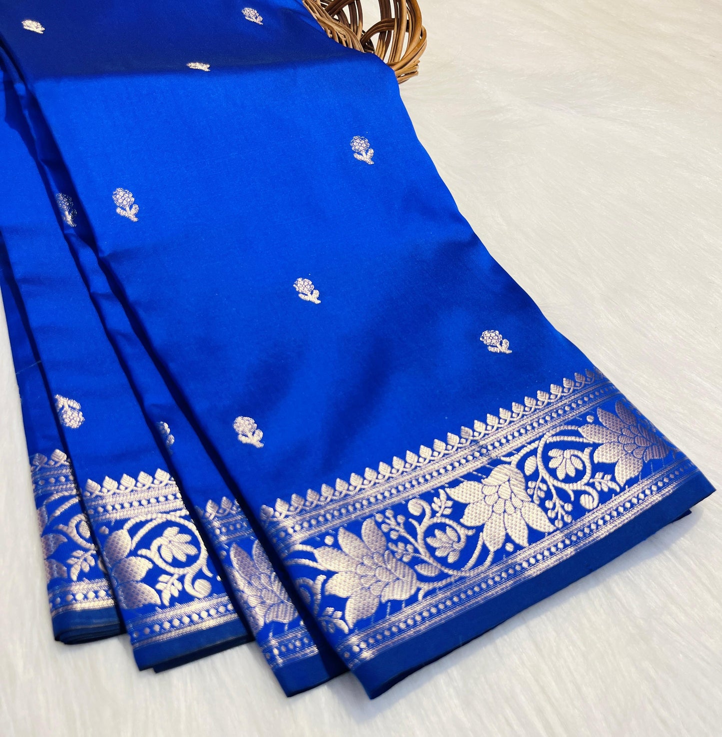 Blue saree with white floral patterns on a white background