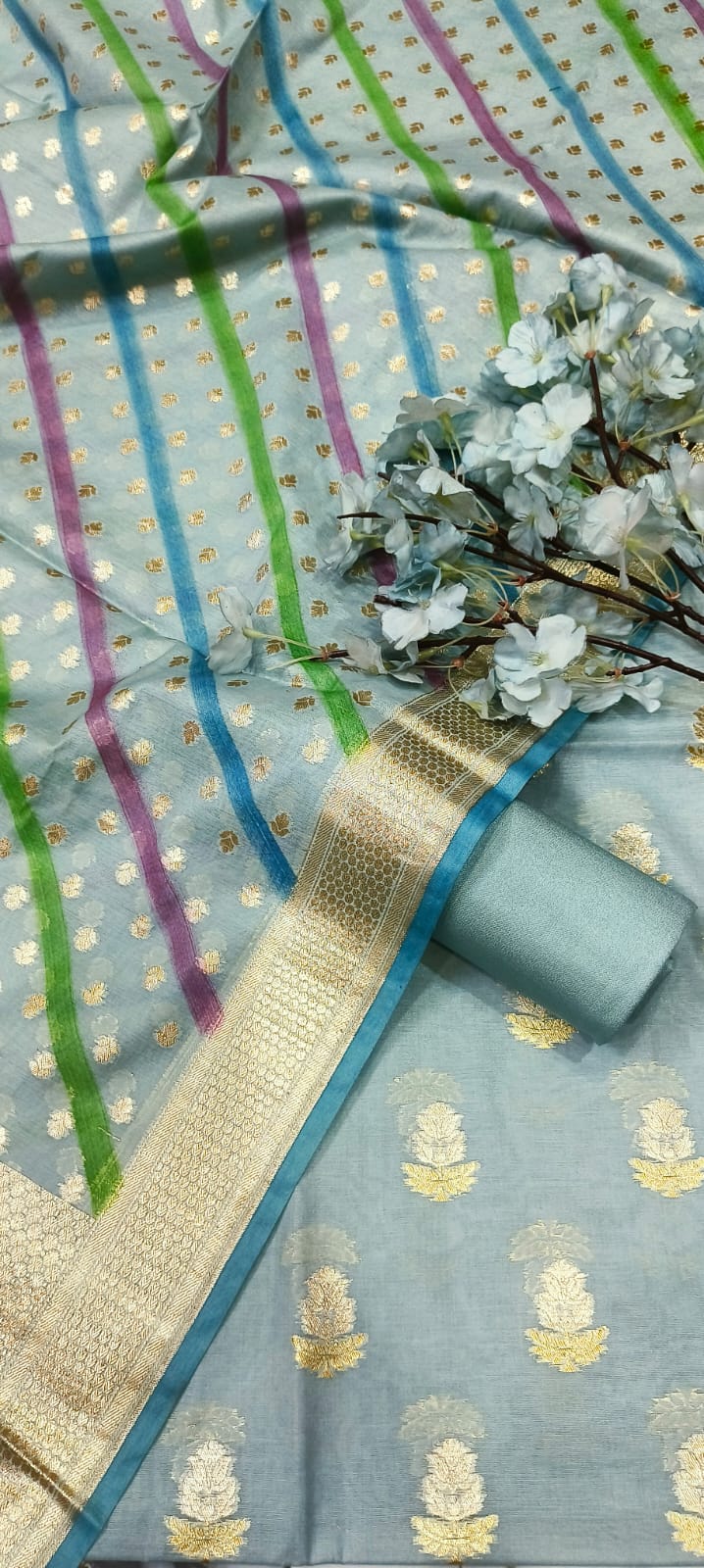 Light blue saree with gold patterns and a decorative border on a striped background